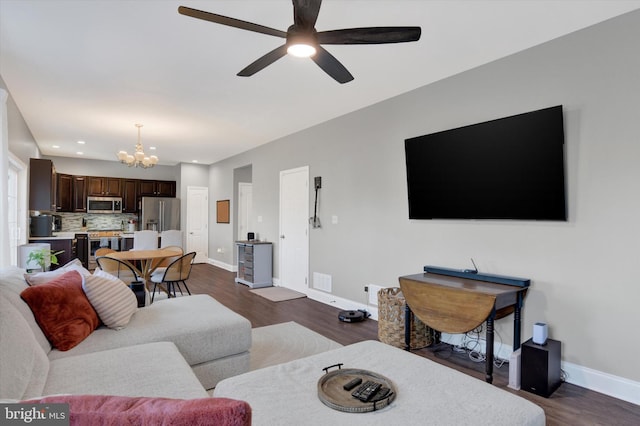 living area featuring visible vents, ceiling fan with notable chandelier, dark wood-style floors, recessed lighting, and baseboards