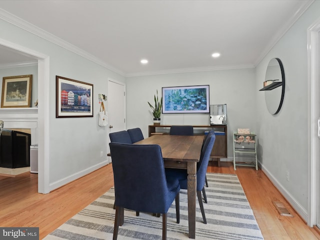 dining room featuring crown molding and light wood-style floors