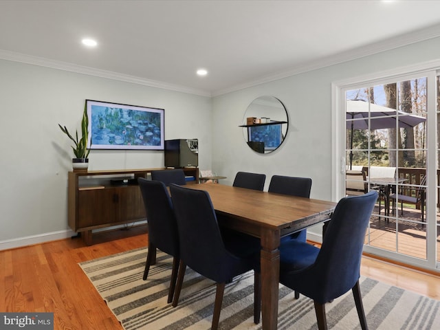 dining space with recessed lighting, crown molding, light wood-type flooring, and baseboards