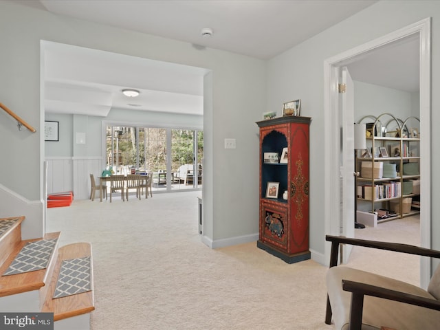 sitting room with baseboards, carpet, and stairs