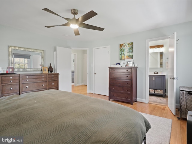 bedroom with light wood-style flooring, ensuite bathroom, baseboards, and ceiling fan