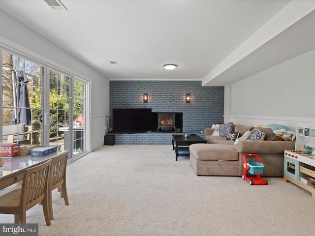 carpeted living area with a fireplace, visible vents, and a wainscoted wall