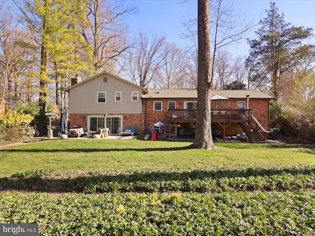 rear view of house featuring a yard, brick siding, a deck, and stairs