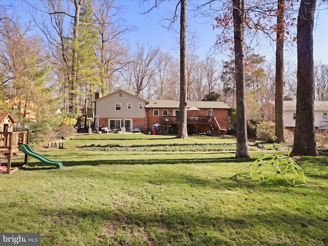 view of yard featuring stairs, a playground, and a wooden deck