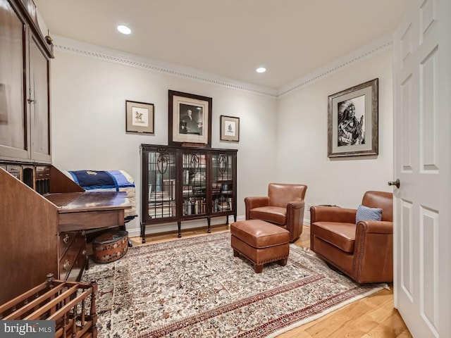 sitting room featuring ornamental molding, recessed lighting, baseboards, and wood finished floors