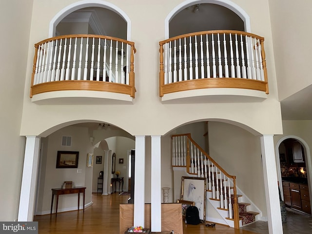 interior space featuring a high ceiling, wood finished floors, visible vents, and baseboards