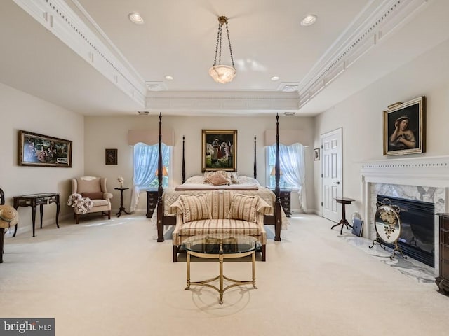 bedroom featuring ornamental molding, a tray ceiling, and light carpet