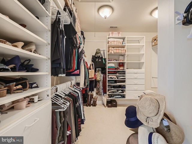 spacious closet with attic access, carpet, and visible vents