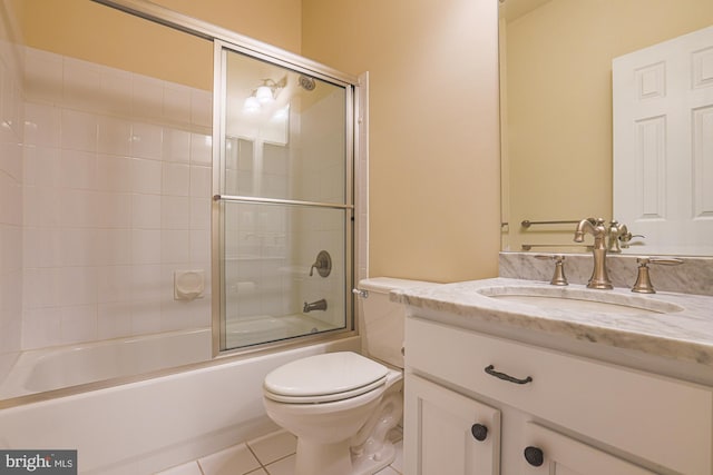 bathroom featuring tile patterned flooring, shower / bath combination with glass door, vanity, and toilet