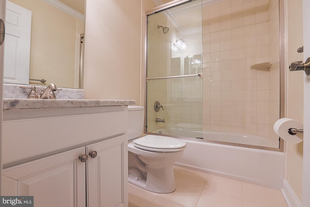 full bath with bath / shower combo with glass door, toilet, ornamental molding, tile patterned flooring, and vanity