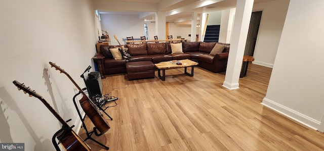 living room featuring baseboards, stairway, and light wood-style floors