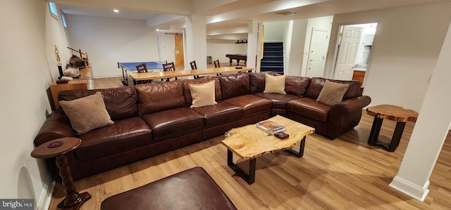 living area featuring light wood-style floors, visible vents, stairway, and baseboards