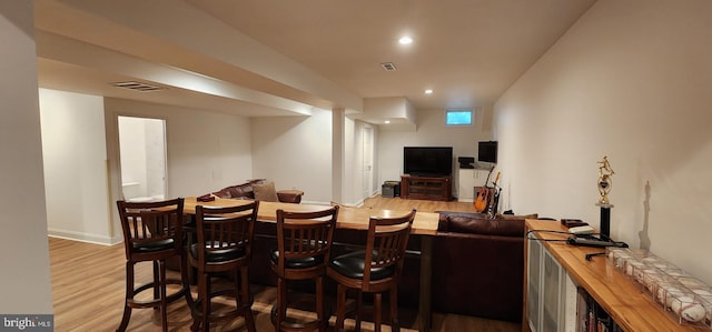 dining room featuring baseboards, visible vents, wood finished floors, and recessed lighting