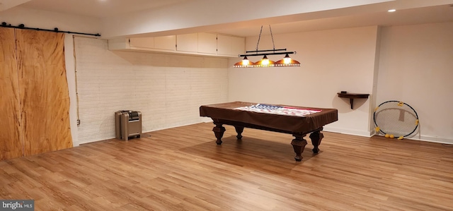 game room featuring a barn door, billiards, baseboards, brick wall, and light wood-style floors