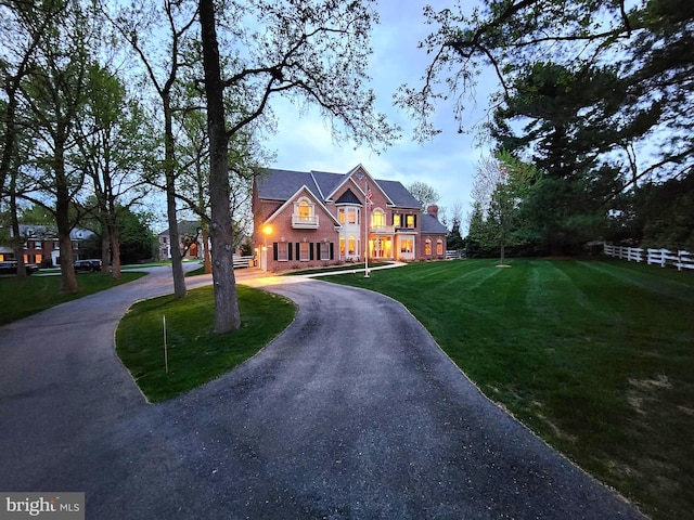 view of front facade with a front yard and curved driveway