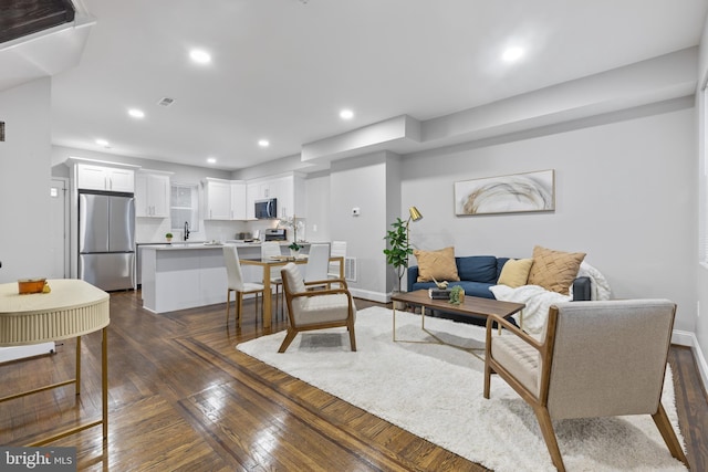 living room featuring baseboards, dark wood-type flooring, visible vents, and recessed lighting