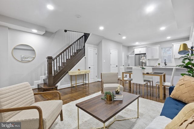 living area with stairs, baseboards, wood finished floors, and recessed lighting