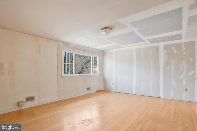 unfurnished room with wood finished floors and visible vents