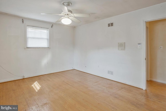 unfurnished room featuring baseboards, light wood-type flooring, visible vents, and a ceiling fan