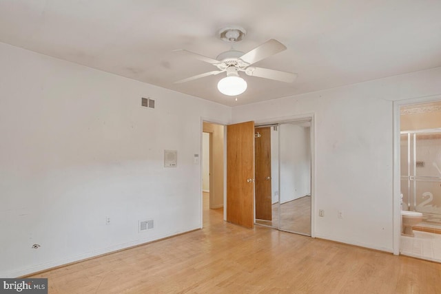 unfurnished bedroom with baseboards, a closet, visible vents, and wood finished floors