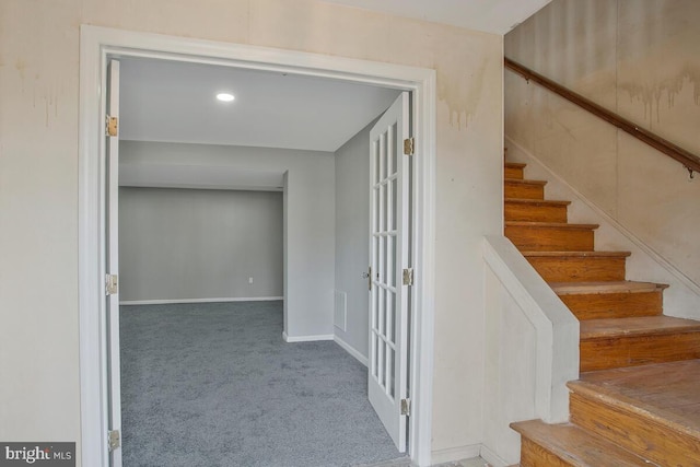 stairs with carpet floors, visible vents, and baseboards