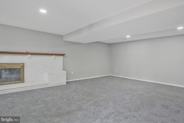 unfurnished living room with carpet, a brick fireplace, baseboards, and recessed lighting