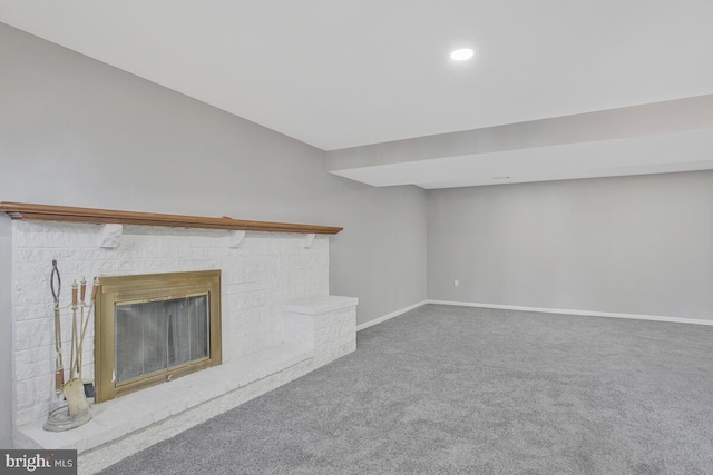 unfurnished living room with carpet, recessed lighting, a brick fireplace, and baseboards