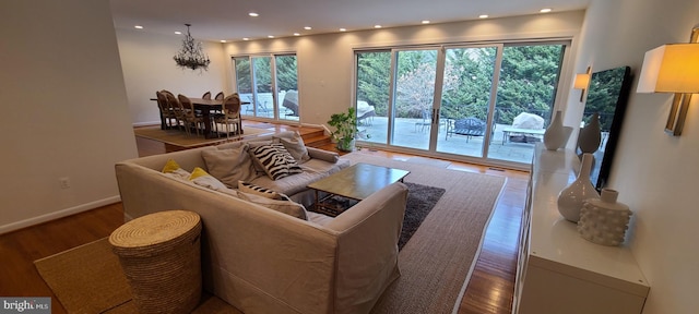 living area featuring a healthy amount of sunlight, baseboards, wood finished floors, and recessed lighting