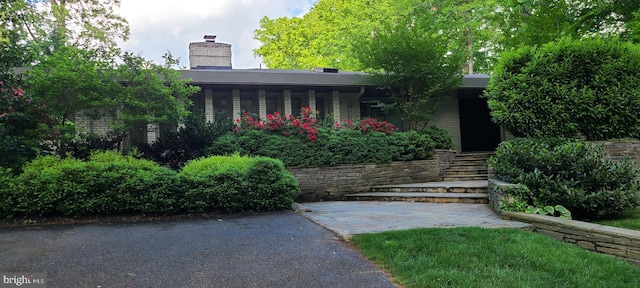 exterior space with brick siding and a chimney