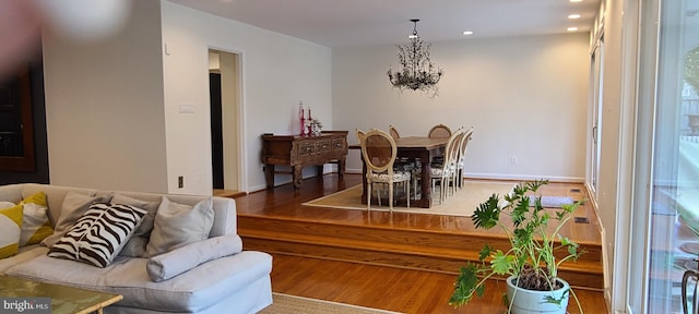 dining space featuring recessed lighting, an inviting chandelier, and wood finished floors