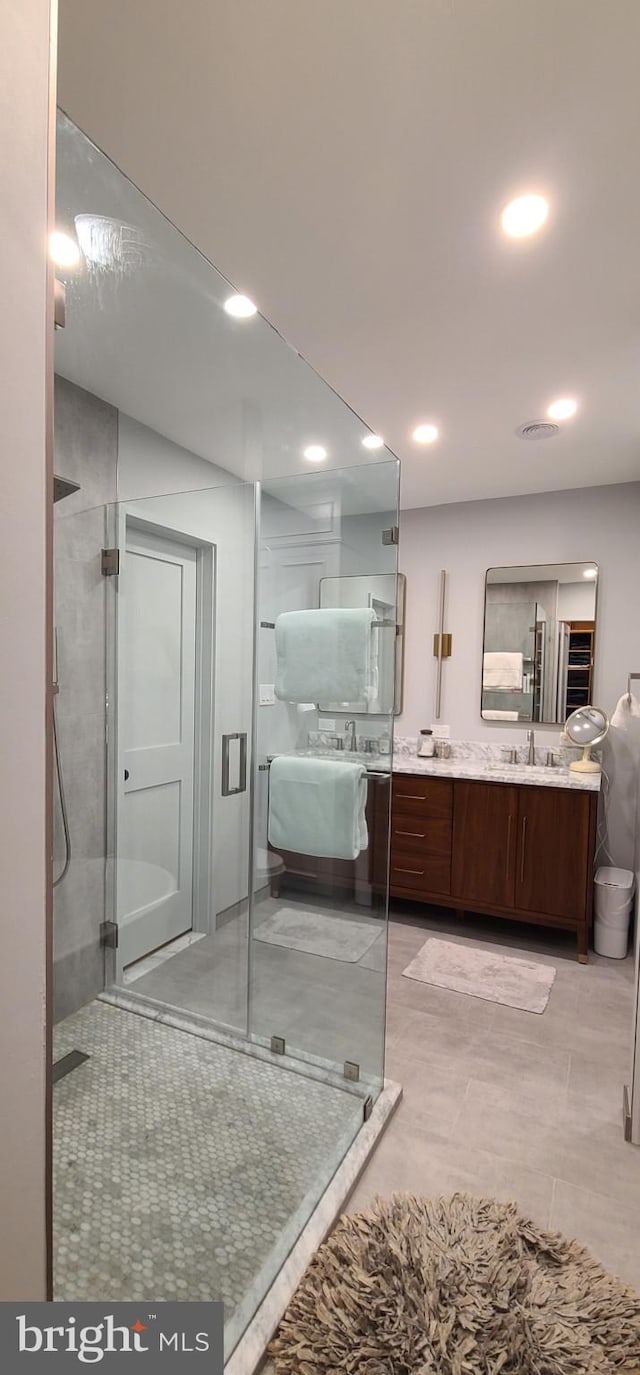 bathroom with recessed lighting, a shower stall, tile patterned flooring, and vanity