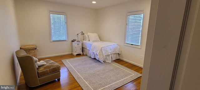 bedroom with baseboards, wood finished floors, and recessed lighting