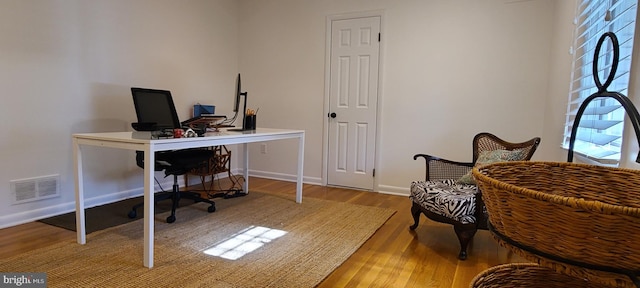 home office featuring baseboards, visible vents, and wood finished floors