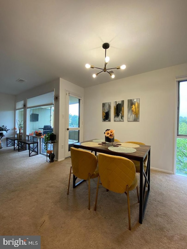 carpeted dining room featuring baseboards, visible vents, a chandelier, and a wealth of natural light