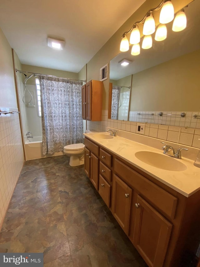 full bathroom featuring double vanity, visible vents, shower / tub combo with curtain, a sink, and tile walls