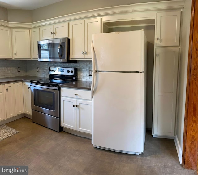 kitchen with stainless steel appliances, dark countertops, backsplash, and white cabinets