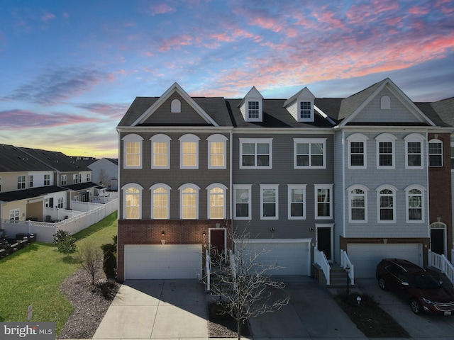 multi unit property featuring a garage, fence, concrete driveway, and a front yard