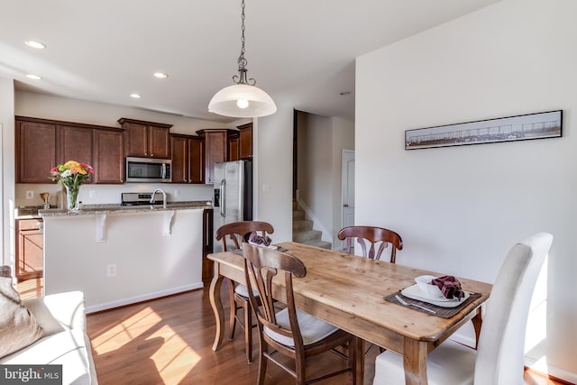 dining room with stairs, light wood-type flooring, and recessed lighting