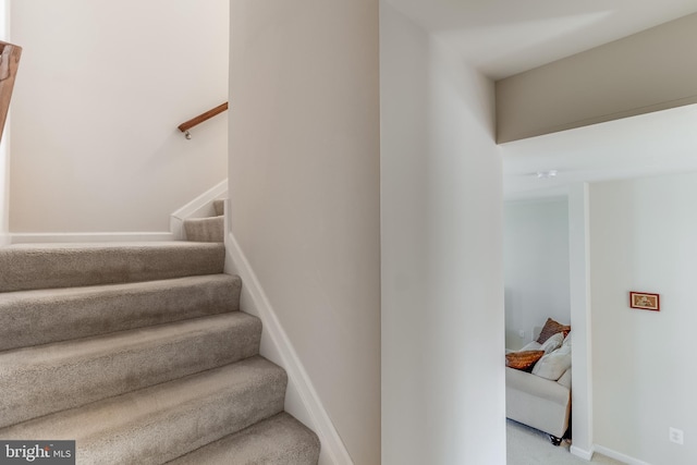 stairs featuring carpet flooring and baseboards