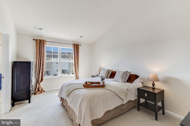 bedroom with vaulted ceiling, baseboards, visible vents, and light colored carpet