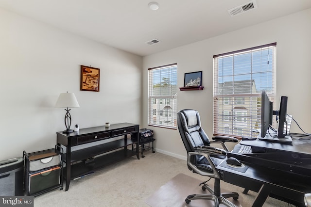 carpeted office space with visible vents and baseboards