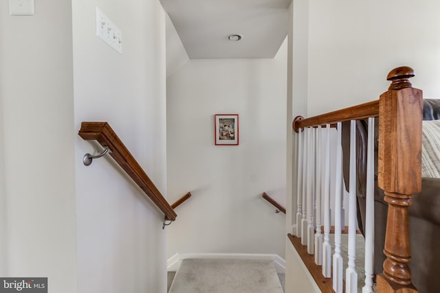 staircase featuring carpet floors and baseboards