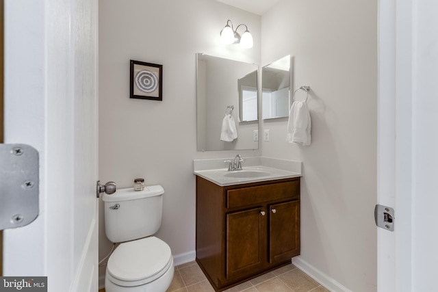 bathroom featuring baseboards, vanity, toilet, and tile patterned floors