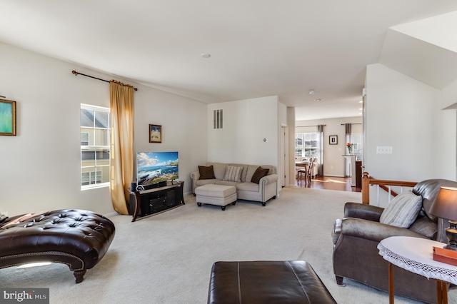 living room with carpet, visible vents, and a healthy amount of sunlight