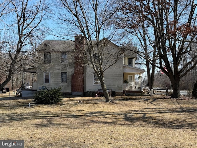 view of front of home with covered porch and a chimney