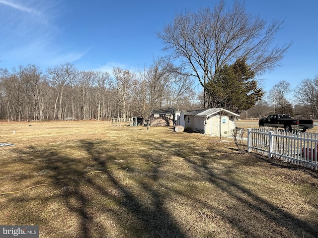 view of yard featuring fence and an outbuilding