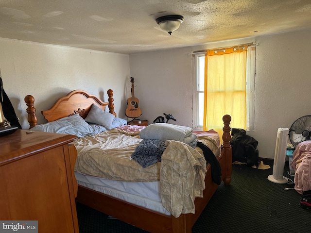 bedroom with a textured ceiling, carpet flooring, and a textured wall