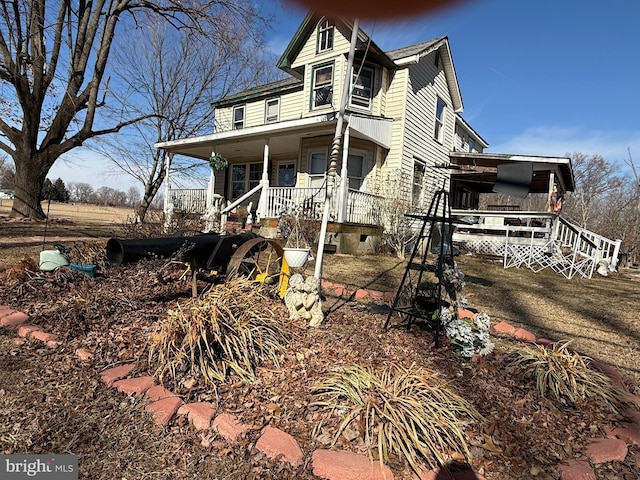 view of side of home with stairs and a porch