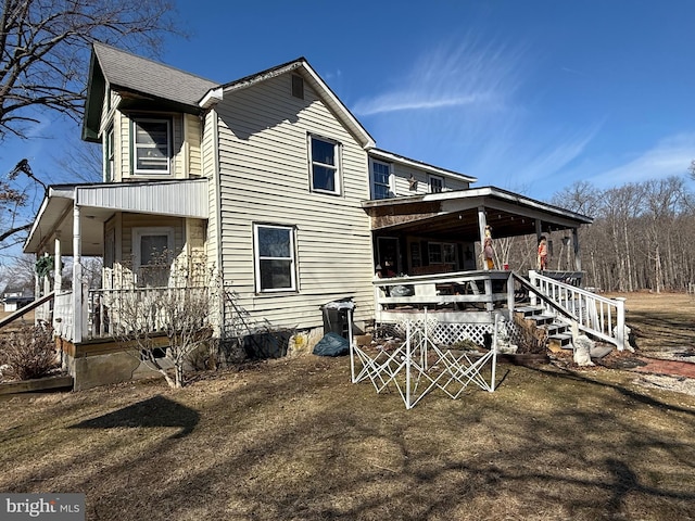 rear view of property with a shingled roof and a porch