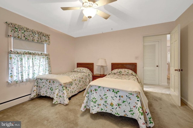 bedroom with a baseboard heating unit, carpet floors, and a ceiling fan